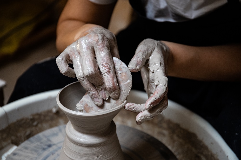 Yuka Hata sta creando un vaso nel suo laboratorio Isola Lab Milano usando il tornio e le sue mani.