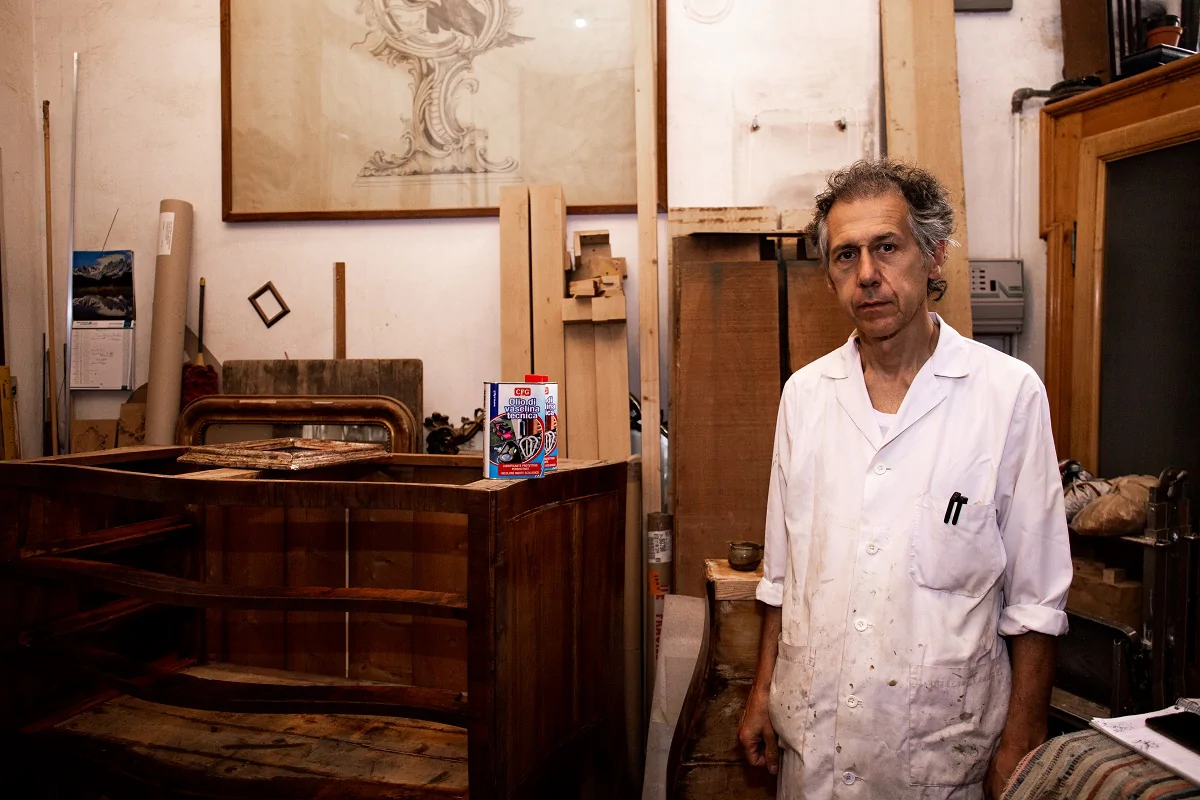Sandro Rongione, restauratore di mobili antichi a Milano, nel suo laboratorio nel mezzo degli ultimi pezzo lavorati.